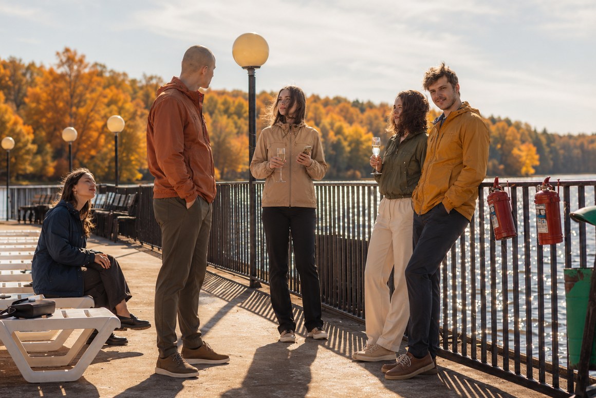 Компания отдыхает на площадке у воды осенью